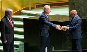 यूएन महासभा के 76वें सत्र के अध्यक्ष अब्दुल्ला शाहिद, 77वें सत्र के अध्यक्ष कसाबा कोरोसी को ज़िम्मेदारियाँ सौंपते हुए. बाईं तरफ़, यूएन प्रमुख एंतोनियो गुटेरेश खड़े हैं.