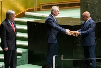 Abdulla Shahid (à droite), Président de la 76e session de l'Assemblée générale, remet le marteau à Csaba Kőrösi, Président de la 77e session. A gauche, le Secrétaire général de l'ONU, António Guterres.