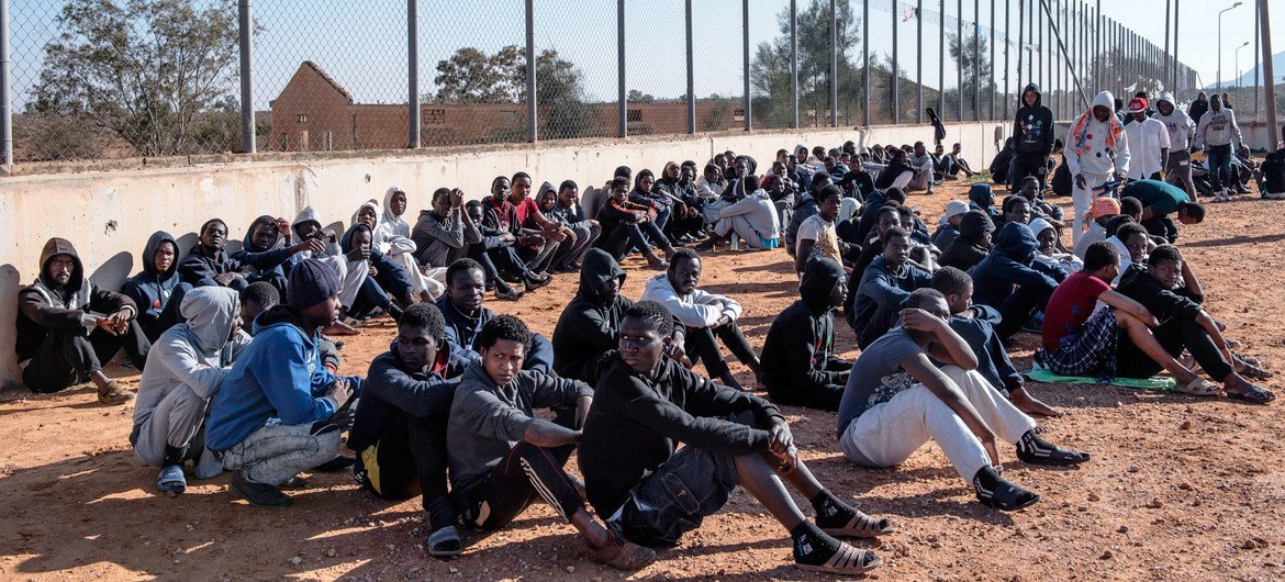 Migrantes sentam-se no pátio de um centro de detenção na Líbia (foto de arquivo).