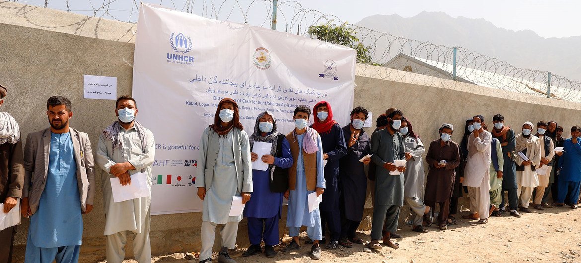 Displaced people wait in line at a distribution site in Kabul, Afghanistan.