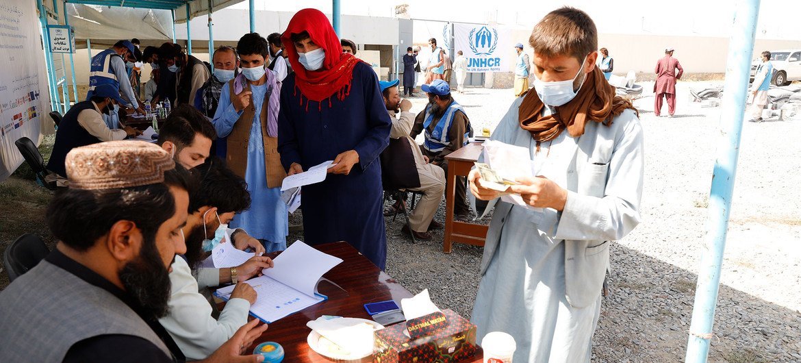 Displaced people receive aid at a distribution site in Kabul, Afghanistan.