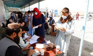 Displaced people receive aid at a distribution site in Kabul, Afghanistan.