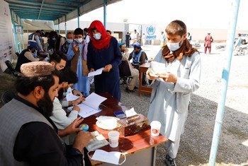 Displaced people receive aid at a distribution site in Kabul, Afghanistan.