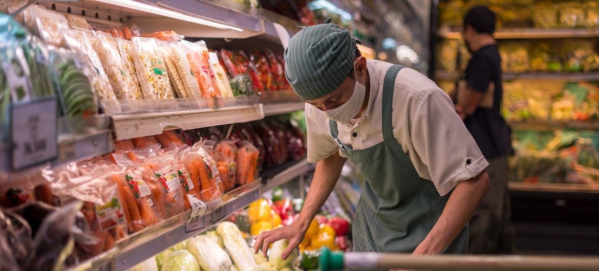 An employee arranges vegetables in a supermarket in Indonesia.