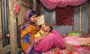 In Bangladesh, a mother holds her 27-day-old baby who has just returned home after 8 days of hospital treatment for pneumonia.