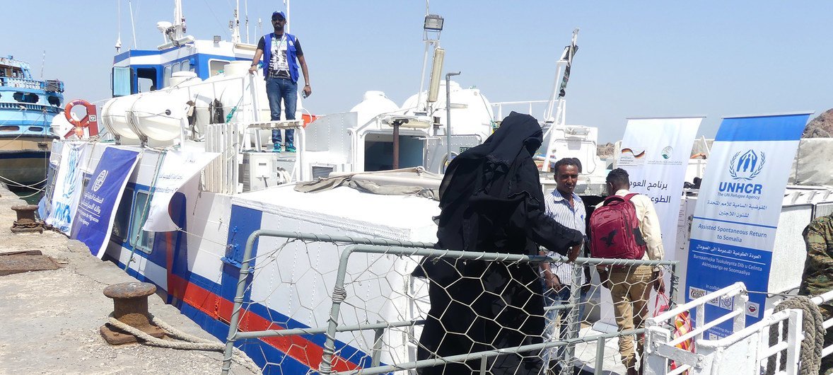 لاجئة صومالية خلال صعودها قاربا في ميناء عدن في طريق عودتها إلى ديارها.