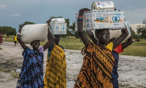 Mulheres carregam ajuda humanitária do PMA em Thaker, no Sudão do Sul