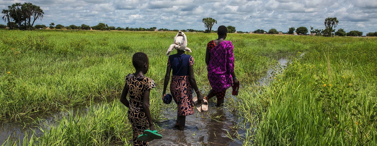 Une femme et sa famille traversent une plaine inondée pour atteindre leur domicile à Thaker, dans l'État de l'Unity, au Soudan du Sud. (archives)