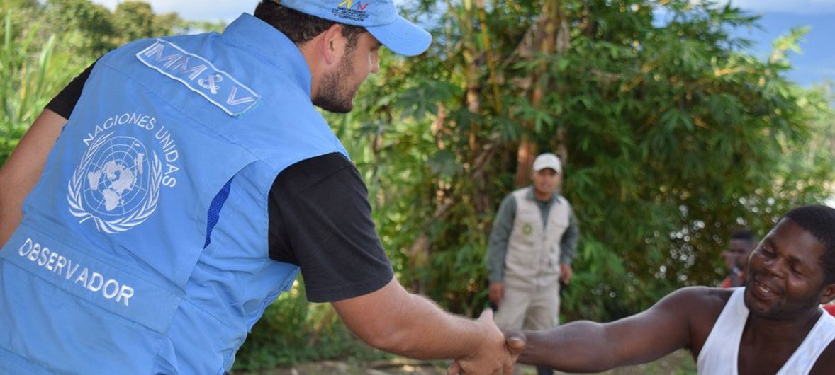 Un integrante de la Misión de Verificación de las Naciones Unidas en Colombia saluda a un excombatiente durante un viaje al departamento de Antioquia.