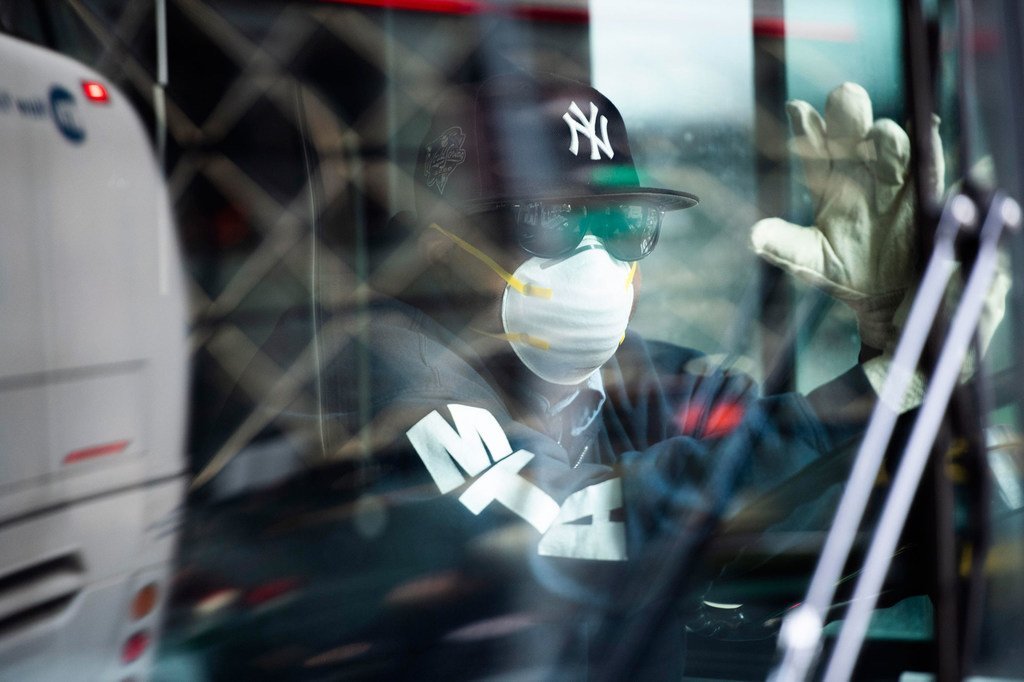 纽约市的一名公交车司机戴着口罩保护自己免受冠状病毒的侵害。