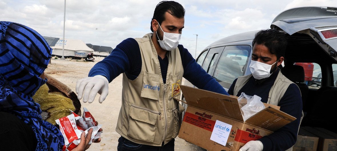 儿基会与合作伙伴在叙利亚拉卡省的难民营分发食品援助。