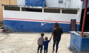 一名来自萨尔瓦多的母亲带着两个孩子走进墨西哥南部一家由难民署运营的登记中心。