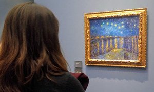 Woman at Musée d'Orsay in Paris gazes at  Vincent Van Gogh painting from 1888.
