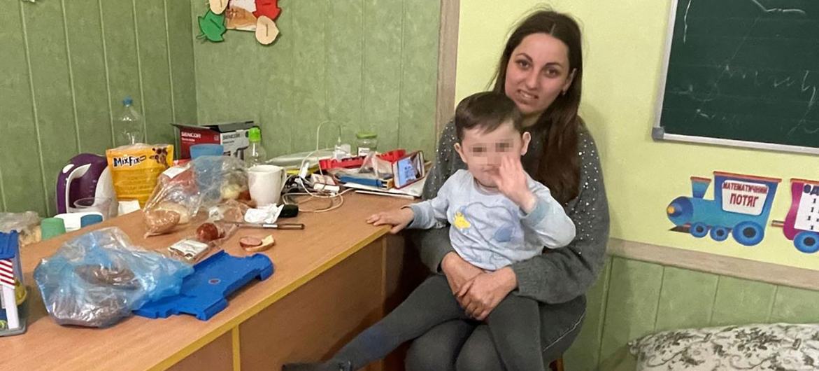 أم فرت من بوتشا مع عائلتها تجلس مع ابنها في ملجأهم الحالي في زاكارباتيا، أوكرانيا.
