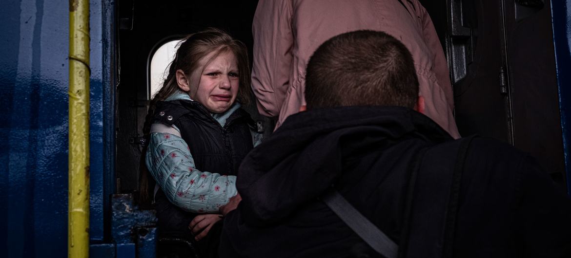 Юная жительница Харькова, вынужденная бежать от войны, плачет, расставаясь с отцом. 