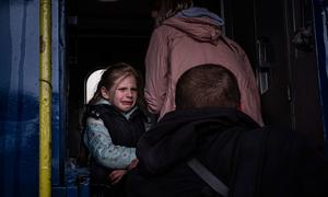 在乌克兰的哈尔科夫，一个女孩在与兄弟和母亲一起登上一辆特殊疏散火车时，哭着告别父亲。