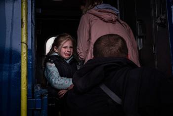 في مدينة خاركيف الأوكرانية، فتاة تبكي وهي تودع والدها أثناء ركوب قطار إجلاء خاص مع شقيقها ووالدتها.