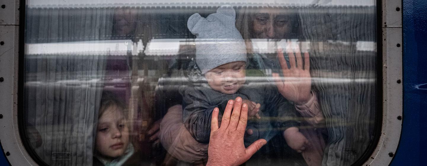 Em Kharkiv, na Ucrânia, homem se despede de sua esposa e filhos antes de partirem em um trem especial de evacuação