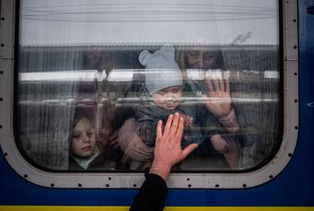 In Kharkiv, Ukraine, a man places his hand to the window of a train car as he says goodbye to his wife and children before they depart on a special evacuation train.