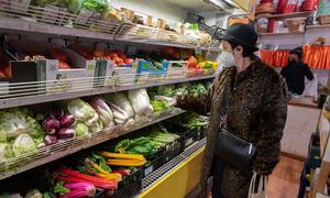 一名妇女在意大利罗马的有机农场商店购买新鲜蔬菜。