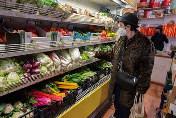 一名妇女在意大利罗马的有机农场商店购买新鲜蔬菜。
