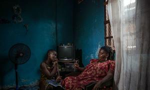 Aicha, the head of Nessemon, a widows’ advocacy group in Côte d’Ivoire, sits with her granddaughter inside their home.