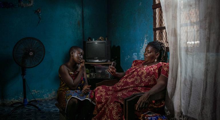 Aicha, the head of Nessemon, a widows’ advocacy group in Côte d’Ivoire, sits with her granddaughter inside their home.