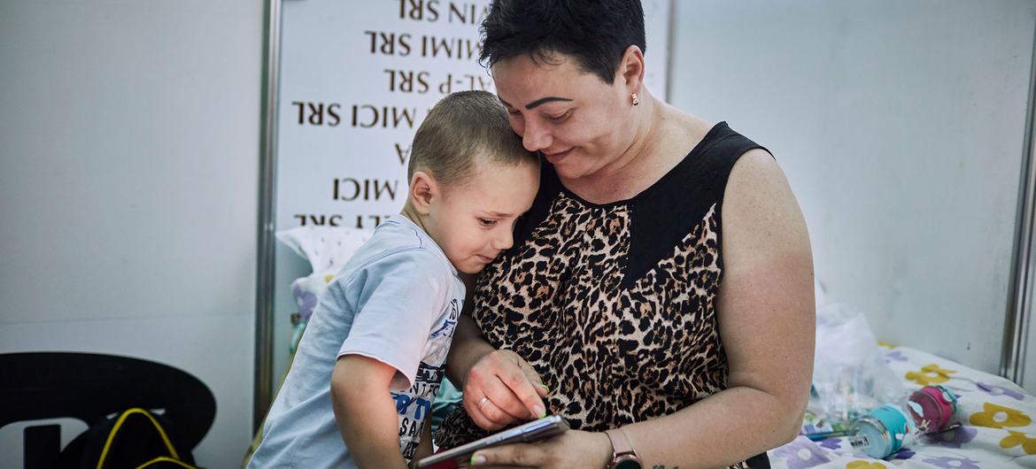 Une mère ukrainienne et son fils regardent une photo de famille dans leur chambre d'un centre d'hébergement pour réfugiés à Chisinau, en Moldavie.