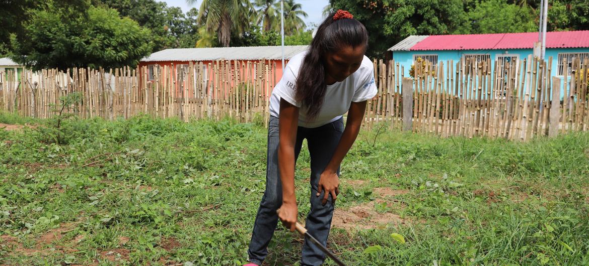 Integrante de la red de mujeres y participante en la huerta preparando la tierra para la siembra.