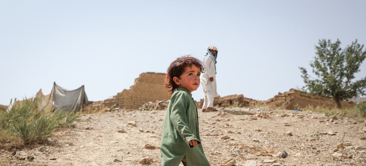 Юный афганец на фоне своего разрушенного дома.  