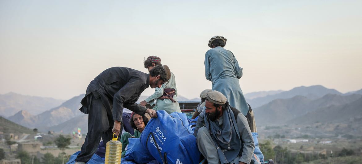 مجموعة من الأشخاص تجمع الملاجئ الطارئة التي وزعتها المنظمة الدولية للهجرة للانتقال مؤقتًا إلى المخيم.