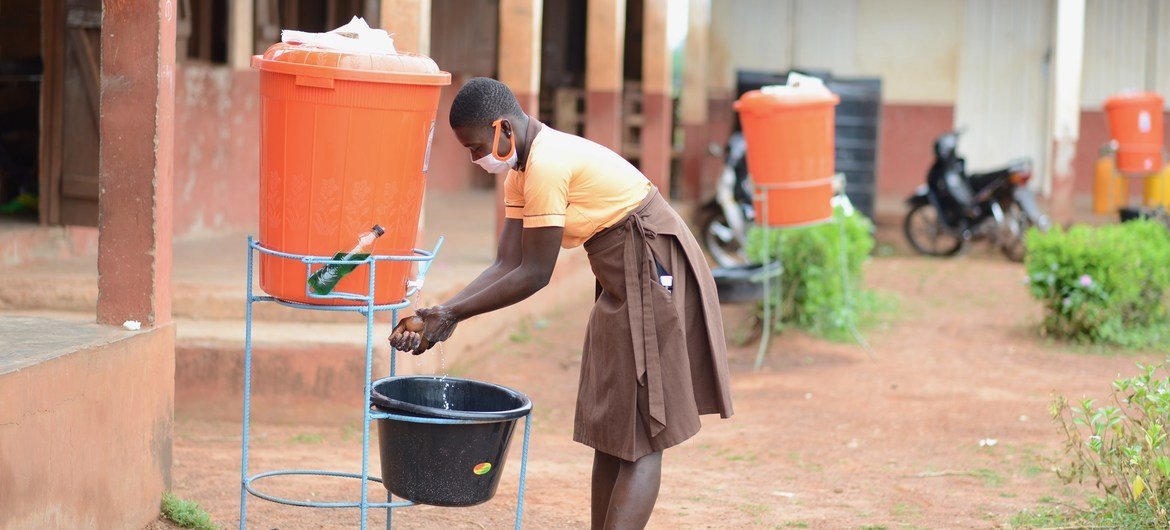 Una joven de Ghana se lava las manos antes de regresar a su salón de clases.