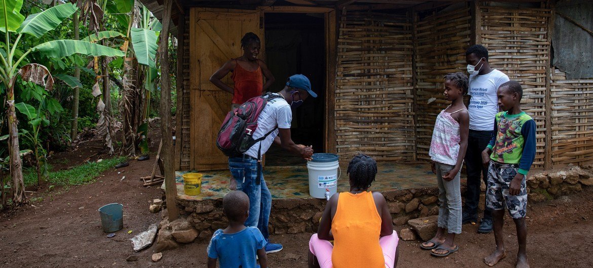 En Haïti, une équipe de l'UNICEF rend visite à une famille dans la petite ville de Dame-Marie, dans le département de Grand'Anse, pour sensibiliser à la Covid-19.