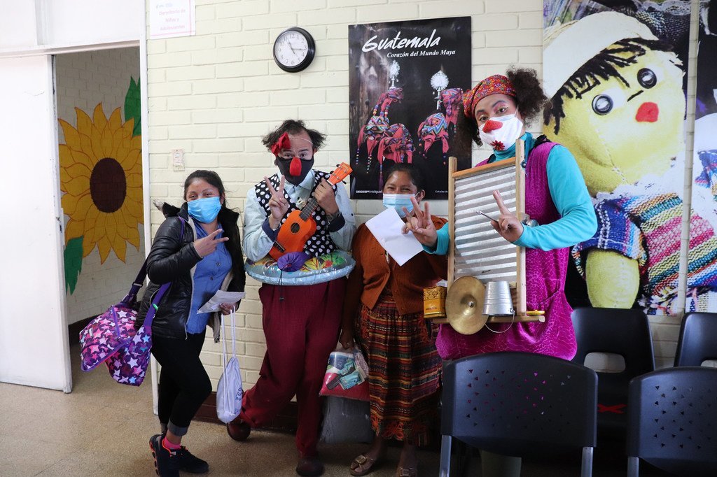 Miembros de "Me quito el sombrero producciones", una compañía teatral guatemalteca dedicada a la creación de espectáculos circenses, acompañan a uno de los niños migrantes retornados en el proceso de reunificación y salida del albergue.