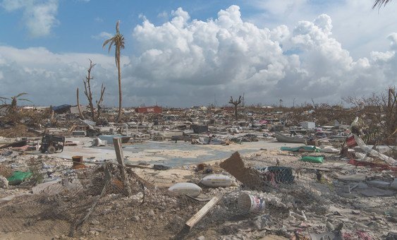 Destruição generalizada em Marsh Harbor, Abaco, Bahamas, após a passagem do furacão Dorian em setembro de 2019, com destroços espalhados pela paisagem sob um céu nublado.