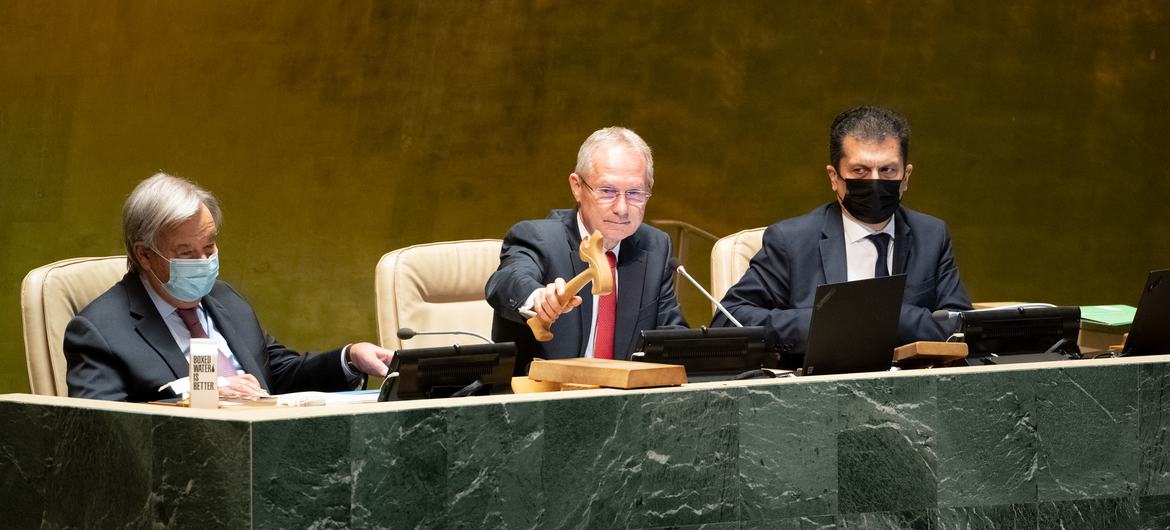 यूएन महासभा के 77वें सत्र के लिये अध्यक्ष कसाबा कोरोसी. उनकी बाईं ओर हैं महासचिव एंतोनियो गुटेरेश, और दाईं और हैं, महासभा व सम्मेलन प्रबन्धन के लिये अवर महासचिव मोवसेस एबेलियन.