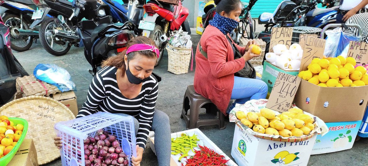 在菲律宾，从事非正规经济的人正面临着被新冠疫情影响而摧毁生计的危险。图为妇女在街边卖水果和蔬菜。