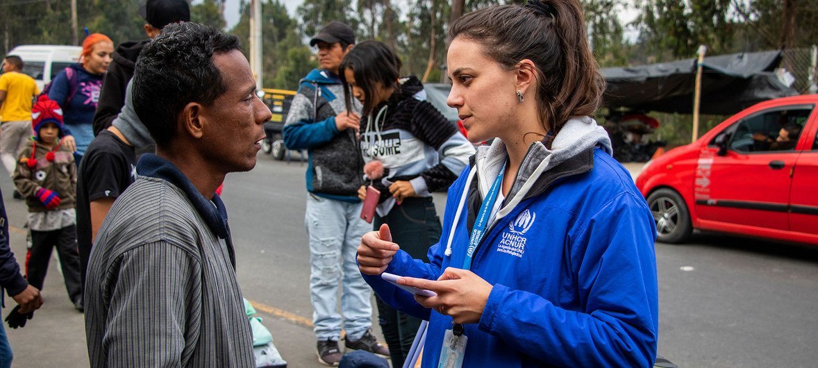 Una trabajadora de ACNUR en el Puente Internacional Rumichaca asiste a los refugiados y migrantes venezolanos que cruzan de Colombia a Ecuador.
