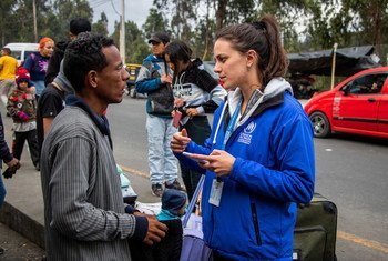 Una trabajadora de ACNUR en el Puente Internacional Rumichaca asiste a los refugiados y migrantes venezolanos que cruzan de Colombia a Ecuador.