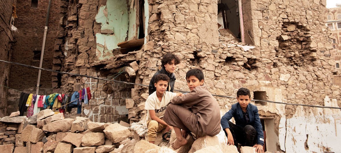 也门儿童在一处被空袭摧毁的房屋废墟前。（2019年7月图片）