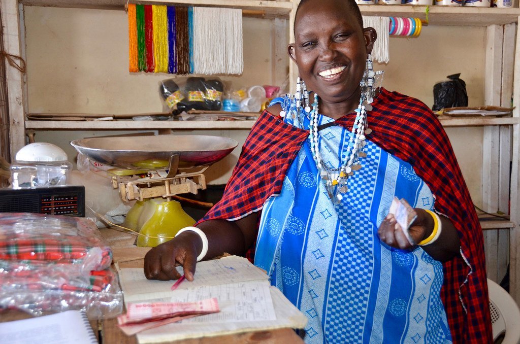 Une femme entrepreneur travaille dans sa boutique sur un marché de village à Arusha, en Tanzanie.