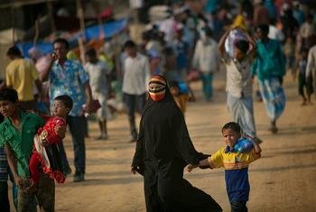 A woman walks through a market in a Rohingya refugee camp in Cox's Bazar, Bangladesh.