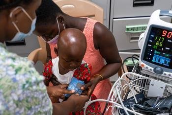 在加纳的一家医院，一名患有癌症的两岁女孩正在接受一名护士的体检。 