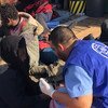 Des migrants qui ont été renvoyés sur les côtes en Libye après avoir tenté de traverser la mer Méditerranée vers l'Europe sont aidés par des travailleurs humanitaires de l'OIM (archive)