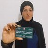 An Arab-Israeli woman shows her COVID-19 card which shows she has been vaccinated against the virus.