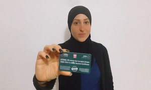 一名阿拉伯裔以色列妇女展示了她的新冠卡，卡上显示她已经接种了新冠疫苗。