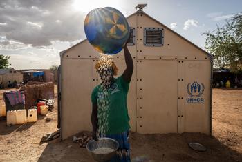 An internally displaced woman prepares food for her family in Burkina Faso.