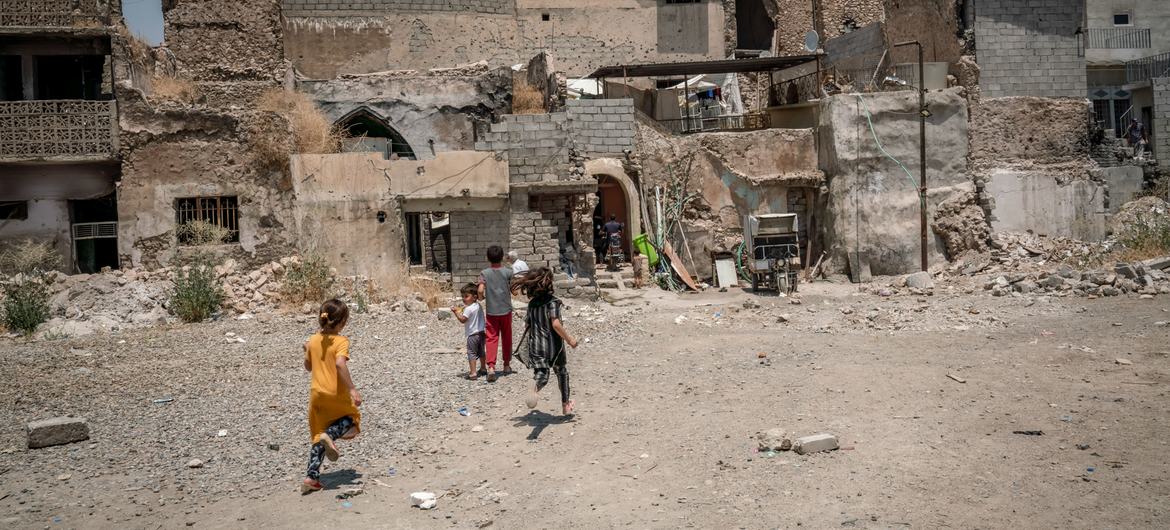 Crianças brincam em um bairro devastado pelo conflito no Iraque.