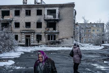 Des gens passent devant un bâtiment détruit par des bombardements dans la région de Donetsk, dans l'est de l'Ukraine (photo d'archives).