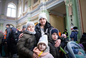 Família da Ucrânia espera em estação de trem para irem para a Polônia. 